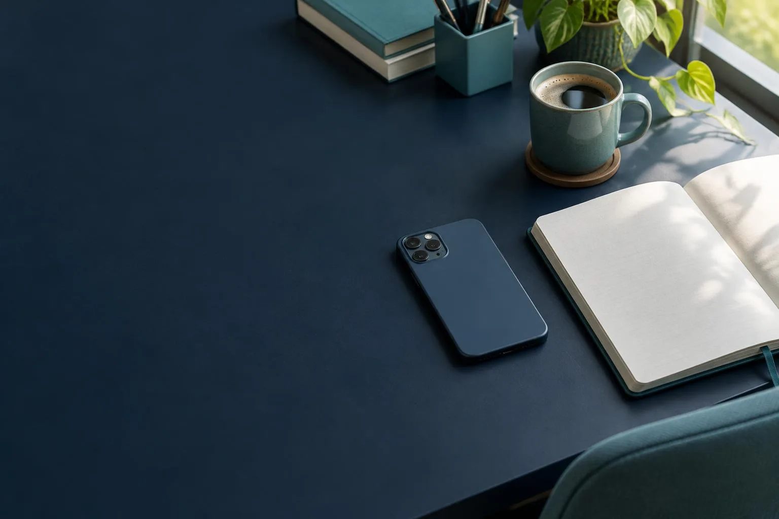 Phone face down beside an open notebook and coffee